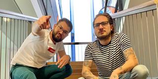 Die Moderatoren Jonas Degen und Moritz Braun auf einer Treppe (Foto: SR/Elena Oberhauser)