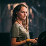 Eine Frau mit grauem T-Shirt und Kopfhörern steht auf einer Bühne. (Foto: Pressefoto/Nora en Pure)