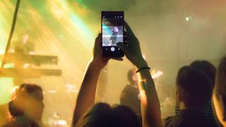 Ein Handy wird bei einem Konzert hochgehalten. Man sieht den Bildschirm und was gefilmt wird. (Foto: pexels/mantas hesthaven)