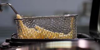 Pommes Frites werden aus einer Fritteuse gehoben (Foto: SR)