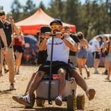 Zwei Festivalbesucher fahren im Bollerwagen über den Campingplatz. (Foto: MxM Photo)