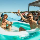 Zwei Festivalbesucher sitzen auf dem Campingplatz in einem Pool. (Foto: MxM Photo)