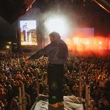 Ein Sänger steht auf einem Turm, im Hintergrund ist eine Bühne und Publikum zu sehen (Foto: MxM Photo)