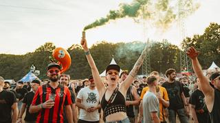 Eine Frau hält eine bunte rauchende Fackel nach oben (Foto: MxM Photo)