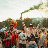 Eine Frau hält eine bunte rauchende Fackel nach oben (Foto: MxM Photo)