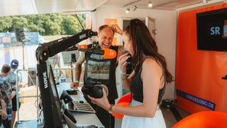 Zwei Personen lachen zusammen. Vor ihnen sind Mikros aufgehängt (Foto: MxM Photo)