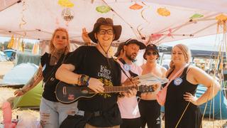 Ein Mann mit einer Gitarre. Dahinter stehen drei Frauen. (Foto: MXM Photo)