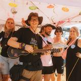 Ein Mann mit einer Gitarre. Dahinter stehen drei Frauen. (Foto: MXM Photo)