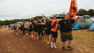 Eine Menschenkette. Der vordere Mann hält eine orangene Fahne hoch. (Foto: MXM Photo)