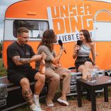 Tokio Hotel beim Interview vor einem orangenen Wohnwagen. (Foto: MXM Photo)