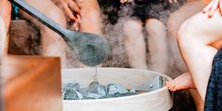 Menschen sitzen in einer Sauna (Foto: unsplash/HUUM)