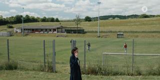 Eine Frau telefoniert, im Hintergrund ist ein Sportplatz zu sehen. (Foto: SR)