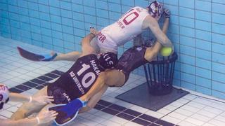 Mehrere Personen befinden sich in einem Schwimmbecken unter Wasser und schwimmen mit einem Ball auf einen Korb am Grund des Beckens zu. (Foto: IMAGO)