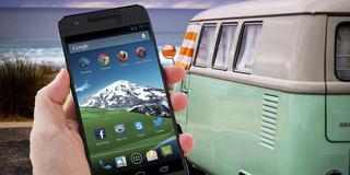 Jemand hält ein Handy vor einem Campingbus in der Hand (Foto: pixabay.com)