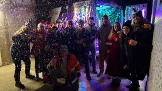 Eine Gruppe von Menschen steht zusammen, es rieselt Kunstschnee (Foto: UNSERDING)