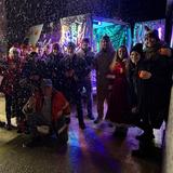 Eine Gruppe von Menschen steht zusammen, es rieselt Kunstschnee (Foto: UNSERDING)