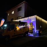 Ein Auto parkt vor einer Garage, die mit Lichterketten geschmückt ist. (Foto: UNSERDING)