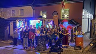 Gruppenbild vor einem weihnachtlich geschmückten Haus. (Foto: UNSERDING)