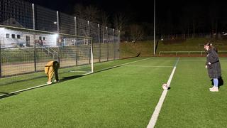 Eine Frau schießt auf ein Tor. Im Tor bückt sich jemand und streckt seinen Hintern entgegen. (Foto: UNSERDING)