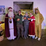 Der Nikolaus und vier weitere Personen  stehen nebeneinander und haben weihnachtliche Accessoires an. (Foto: UNSERDING)