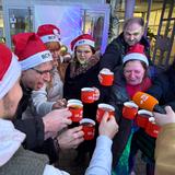 Ein Kreis von Leuten stößt mit gefüllten Tassen an. (Foto: UNSERDING)