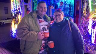 Ein Mann und eine Frau vorm leuchtenden UNSERDING Weihnachtsmobil (Foto: UNSERDING)