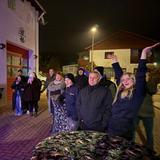 Leute stehen in einer Reihe unf freuen sich. Einige filmen, eine Person reißt die Hände in die Luft, (Foto: UNSERDING)