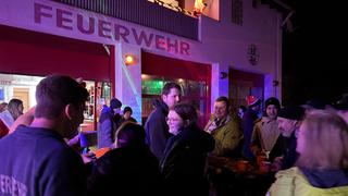 Leute stehen vor einem Gebäude mit dem Schriftzug "Feuerwehr". (Foto: UNSERDING)