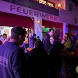 Leute stehen vor einem Gebäude mit dem Schriftzug "Feuerwehr". (Foto: UNSERDING)