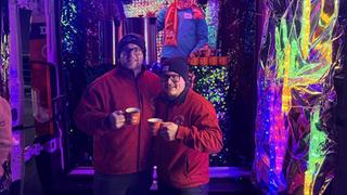 Zwei Männer mit Tassen in der Hand vorm Weihnachtsmobil. (Foto: UNSERDING)